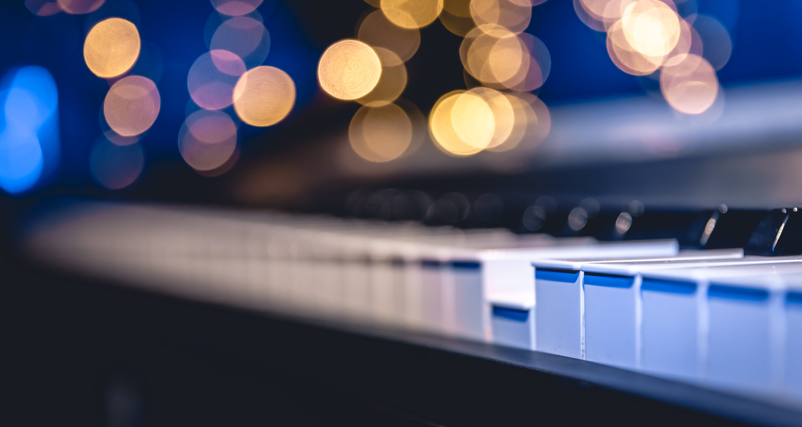 Close up of piano keys on blurred background with bokeh, music background.